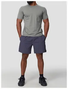 Full body view of a man wearing a gray sun protection quick-dry athletic T-shirt and shorts