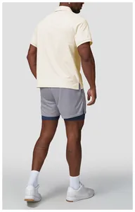 Rückansicht eines cremefarbenen schnell trocknenden Golf-Poloshirts für Herren mit Shorts