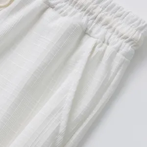 Détail de la taille élastique et de la poche d'un pantalon blanc décontracté pour homme.