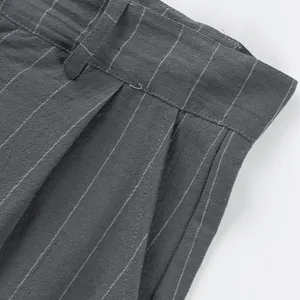 Detail view of breathable grey linen pinstripe fabric and high-quality tailoring on men's trousers