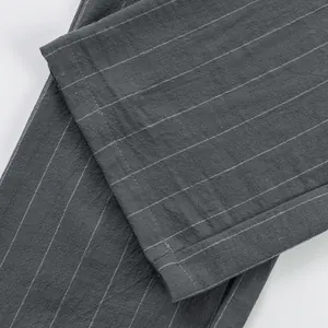 Close-up of grey vertical striped linen pants showing fabric texture and hem detail.