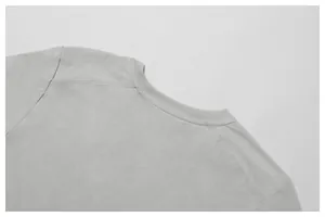 Close-up detail of grey T-shirt collar showing high-quality stitching and fabric texture.