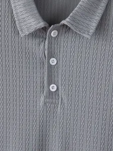 Close-up of grey men's knitted Polo shirt with textured pattern and collar detail.