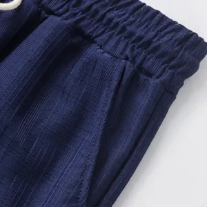 Zoom détaillé sur la taille élastique et le tissu texturé d'un pantalon bleu pour homme