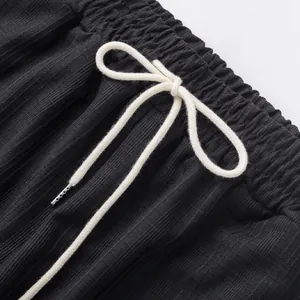 Détail du cordon de serrage blanc sur le pantalon décontracté noir pour hommes