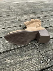 Détail de la semelle texturée et du talon bloc robuste de la botte en daim marron pour femme