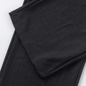 Vue macro de la texture du tissu quadrillé en imitation lin fin sur un pantalon