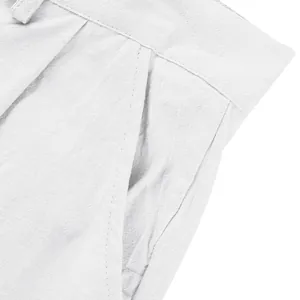 Détail rapproché de la poche et des plis sur un pantalon en lin blanc pour homme