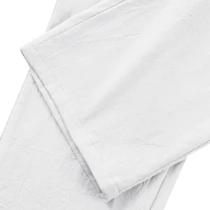 Vue macro de la texture du tissu en lin blanc et détail de l'ourlet du pantalon
