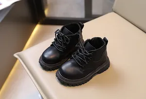 Vista detallada de botas Martin negras estilo inglés para niños en una silla