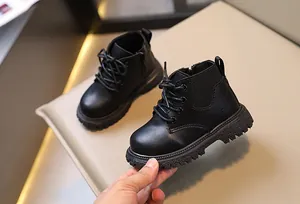 Primer plano de botas Martin para niños en cuero negro con textura y suela gruesa
