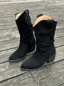 Détail des bottes de cow-boy occidentales en daim noir à bout pointu plissé cuir