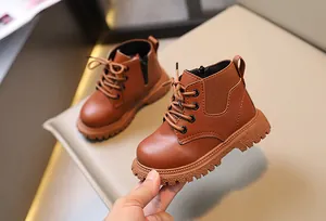 Primer plano de botas Martin marrones para niños con cremallera lateral y suela dentada.