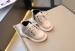 Detalle de los elegantes botines Martin beige para niños con cremallera lateral y cordones.
