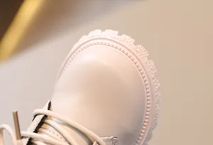 Primer plano de bota blanca para niños que muestra la textura del cuero y la suela dura.