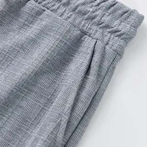 Détail d'un pantalon décontracté gris pour hommes avec tissu quadrillé aspect lin