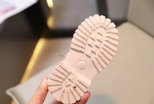 Vista detallada de la suela rosa de una bota Martin infantil con marca de talla 23.
