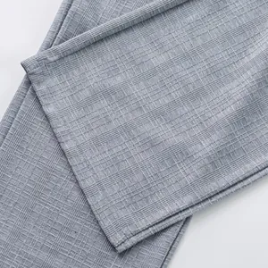 Gros plan détaillé montrant la texture à carreaux gris et l'ourlet du pantalon décontracté