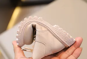 Detalle de la suela de goma suave y flexible de los botines rosas para niños