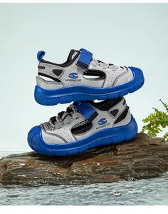 Side view of boys closed-toe blue sport sandals on rock with waterproof mesh design.