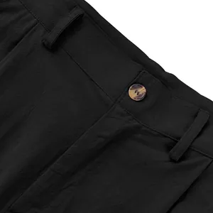Gros plan détaillé de la texture du lin noir et du bouton d'un pantalon décontracté homme