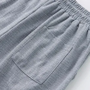 Vue détaillée du tissu gris effet lin et de la poche d'un pantalon décontracté pour homme