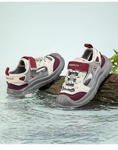 Detailed side view of boys' closed-toe mesh sports sandals on wood over rippling water