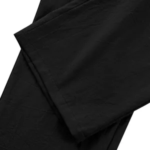 Gros plan de la texture du tissu en lin noir du pantalon décontracté pour hommes.