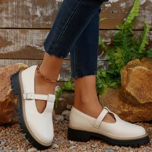 Detalle de zapatos Mary Jane retro crema con suela de plataforma gruesa y hebilla