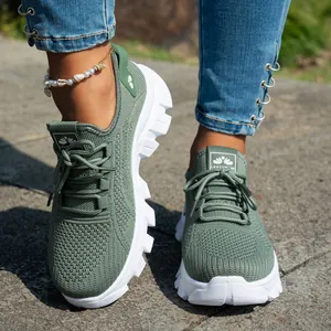 Detalle de zapatillas de punto verde para mujer con suelas blancas gruesas y transpirables.