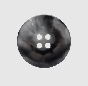 Close-up view of a four-hole marble patterned urea button for high-end garments