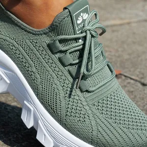 Detalle de cerca de la textura flyknit verde y cordones de zapatillas de mujer