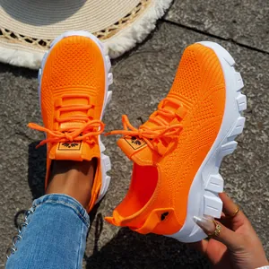 Vista detallada de las zapatillas de punto naranja vibrante con suela blanca gruesa