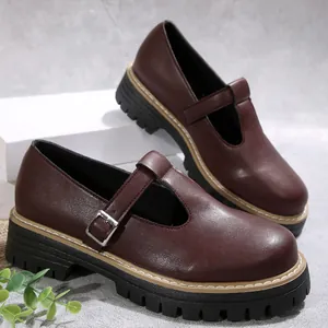 Primer plano de zapatos Mary Jane burdeos vintage con suela gruesa y hebilla metálica