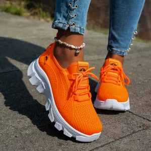 Primer plano de zapatillas de malla naranja vibrante con suelas blancas gruesas