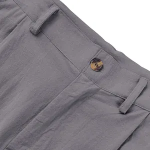 Gros plan sur la taille d'un pantalon décontracté en lin gris avec bouton et passant