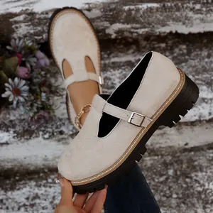 Primer plano de zapato Mary Jane de ante beige con hebilla en T y suela de plataforma.