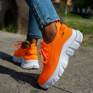 Primer plano de zapatillas de running de punto naranja vibrante con suela gruesa