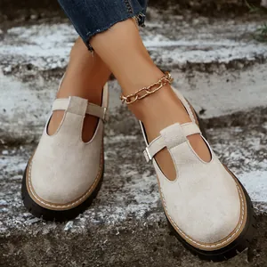 Vista detallada de zapatos Mary Jane beige con tira en T y suela gruesa en una escalera