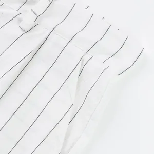Detailed close-up of men's linen striped trousers showing waist and pocket stitching
