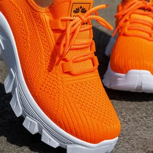 Primer plano detallado de las zapatillas de running de malla fly-knit naranja vibrante
