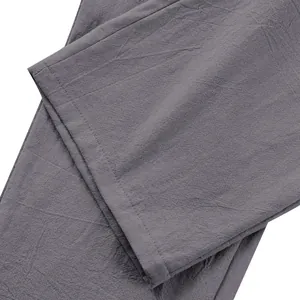 Gros plan sur la texture du tissu en lin gris et l'ourlet d'un pantalon décontracté homme.