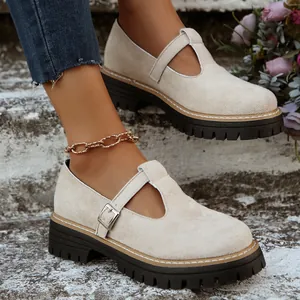 Zapatos Mary Jane beige de punta redonda con suela gruesa de tacos y hebilla.
