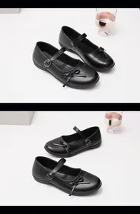 Close-up detail of girls' black vintage Mary Jane flat shoes featuring elegant bow accents