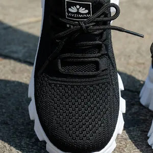 Primer plano de la textura de malla fly-knit negra transpirable de calzado deportivo