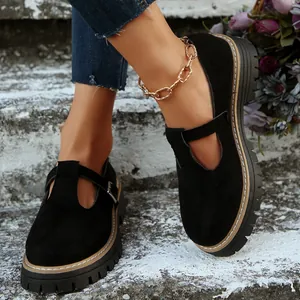 Primer plano de Mary Janes retro de ante negro con punta redonda y suela gruesa.