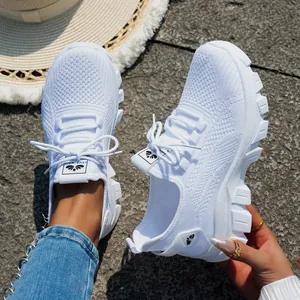 Primer plano de zapatillas blancas de running de punto transpirable con suela gruesa