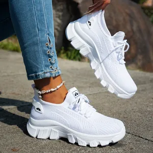 Detalle de zapatillas blancas de punto transpirable con suela blanda y cómoda para mujer