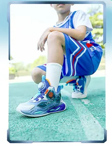 Detail view of professional boys breathable basketball shoes with rotary buckle on a court
