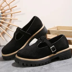 Vista lateral de zapatos Mary Jane de ante negro con suelas gruesas y hebilla vintage